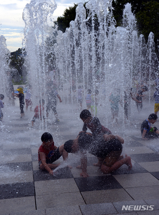 【서울=뉴시스】박태홍 기자 = 더위도 가시고 선선한 가을을 맞이하게 된다는 처서 (處暑) 절기를 닷새 앞둔 18일 오후 서울 성동구 서울숲에서 뭉게구름 사이로 볕이 뜨겁게 내리쬐고 어린이들이 바닥에서 솟아오르는 힘찬 물줄기를 맞으며 즐겁게 놀고 있다. 2018.08.19.&nbsp; hipth@newsis.com