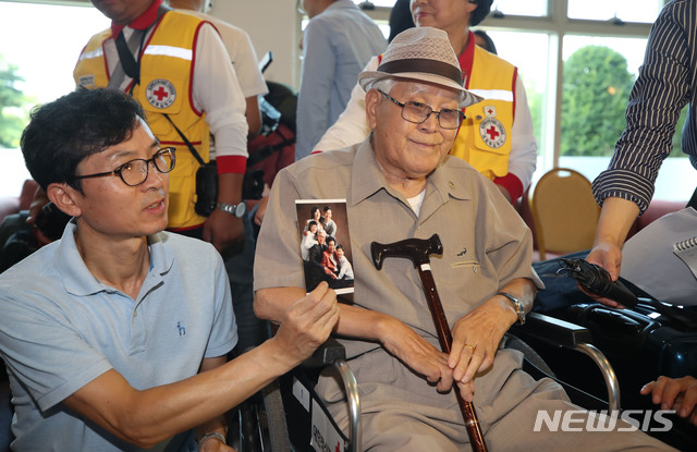 【속초=뉴시스】김진아 기자 =21차 이산가족 상봉을 하루 앞둔 19일 오후 강원도 속초 한화리조트에서 남측 1차 상봉 대상자인 유관식(89) 할아버지와 가족들이 인터뷰 중 가족사진을 보여주고 있다. 유 할아버지는 4촌과 딸을 만날 예정이다.&nbsp; 2년10개월 만에 열리는 이번 이산가족 상봉 행사에는 이산가족 89명과 동반가족 108명 등 총 197명이 20일부터 22일까지 열리는 '1차 이산가족 상봉행사'에 참여할 예정이다. 2018.08.19.&nbsp; bluesoda@newsis.com 