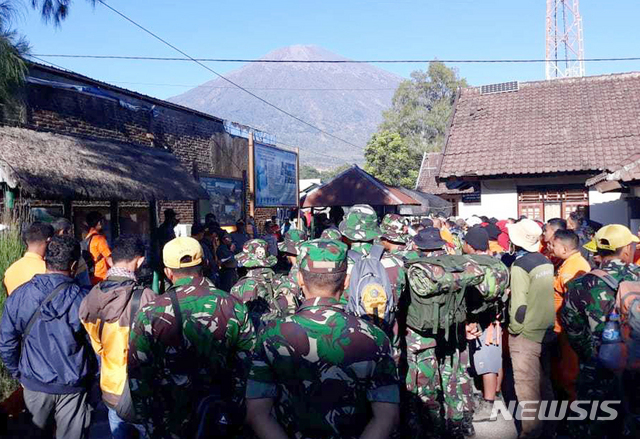 【셈발룬(인도네시아 롬복섬)=AP/뉴시스】지난 7월30일 인도네시아 린자니산이 뒷편으로 보이는 롬복섬 셈발룬에 인도네시아 군인들과 구조대가 지진으로 고립된 관광객들을 구조하기 위해 모여 있다. 19일 롬복섬에 규모 6.9의 지진이 또다시 발생해 최소 12명이 사망했다. 2018.8.20