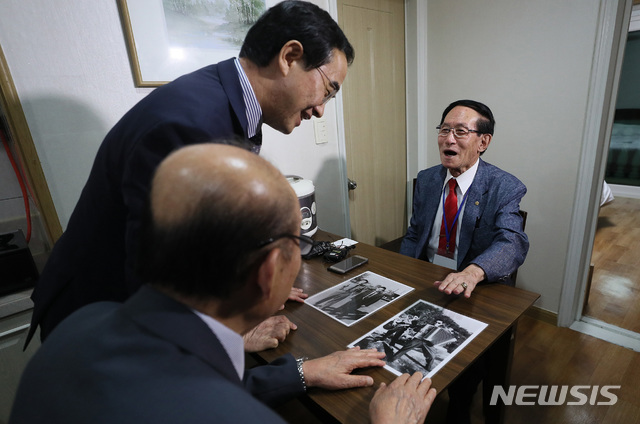 【속초=뉴시스】뉴스통신취재단 = 제21차 이산가족 상봉을 하루 앞둔 19일 오후 강원도 속초시 한화리조트에서 남측 1차 상봉 대상자인 윤흥규(92) 할아버지가 조명균 통일부 장관과 박경서 대한적십자사 회장에게 자신의 군복무 시절 사진을 보여주고 있다. 2년 10개월 만에 열리는 이산가족 상봉은 20일부터 26일까지 금강산에서 진행된다.윤 할아버지는 북측의 매부와 외조카손자를 만날 예정이다. 2018.08.19&nbsp; photo@newsis.com
