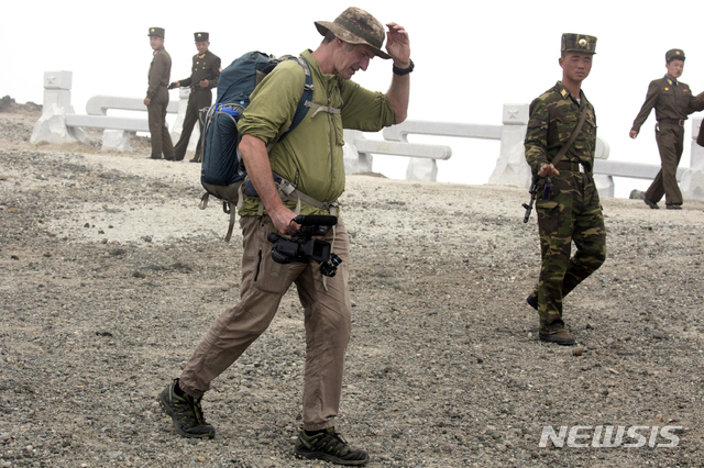 【백두산=AP/뉴시스】뉴질랜드 등반가로 '하이크 코리아(Hike Korea)'를 이끌고 있는 로저 셰퍼드가 18일 북한 백두산에서 군인들 옆을 지나고 있다. 북한과 남한에서 많은 등반을 해본 경험이 있는 셰퍼드는 호주와 노르웨이에서 온 관광객들을 이끌고 북한 백두산에 올라 캠핑도 있다. 북한이 외국인 관광객의 백두산 등반과 캠핑을 허용하기는 이번이 처음이다. 2018.08.20 