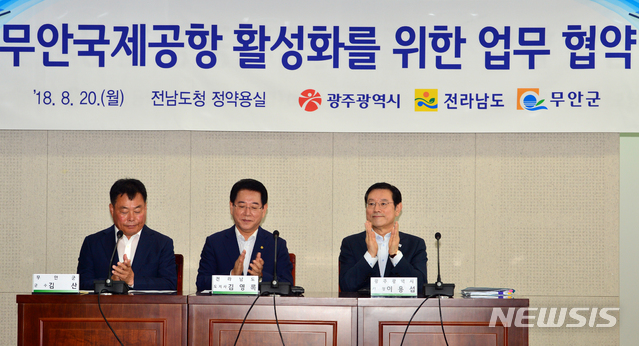 【무안=뉴시스】변재훈 기자 = 20일 오전 전남 무안군 삼향읍 전남도청 정약용실에서 무안공항 활성화를 위한 업무협약식이 열렸다. 협약식에 참석한 (왼쪽부터) 김산 무안군수, 김영록 전남도지사, 이용섭 광주시장이 박수를 치고 있다. 2018.08.20. wisdom21@newsis.com