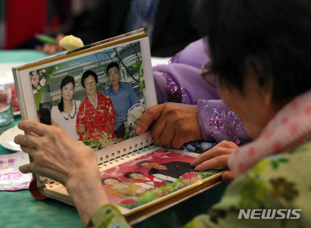 【금강산=뉴시스】뉴스통신취재단 = 제21차 이산가족 상봉행사 1회차 첫날인 20일 오후 금강산호텔에서 열린 단체상봉에서 한신자(99)할머니가 북측의 딸들 김경실(72), 김경영(71)의 사진을 살펴보고 있다. 2018.08.20. photo@newsis.com