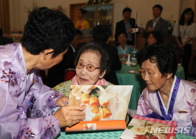 【금강산=뉴시스】뉴스통신취재단 = 제21차 이산가족 상봉행사 1회차 첫날인 20일 오후 금강산호텔에서 열린 단체상봉에서 한신자(99)할머니가 북측의 딸들 김경실(72), 김경영(71)의 사진을 살펴보고 있다. 2018.08.20. photo@newsis.com