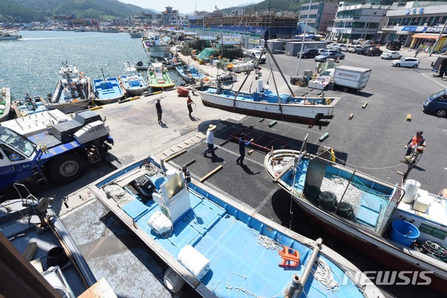 【울산=뉴시스】배병수 기자 = 제19호 태풍 '솔릭'(SOULIK)이 한반도를 향해 북상 중인 가운데 21일 오후 울산시 북구 정자항 어촌계에서 어민들이 크레인을 동원해 소형 어선을 육지로 옮기고 있다. 2018.08.21.&nbsp; bbs@newsis.com.