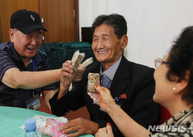 【금강산=뉴시스】뉴스통신취재단 = 제21차 이산가족 상봉행사 1회차 둘째날인 21일 오전 금강산호텔에서 열린 단체상봉에서 남측의 함성찬(93) 할아버지가 북측의 동생 함동찬(79)에게 과자를 먹여주고 있다. 2018.08.21.&nbsp; photo@newsis.com 