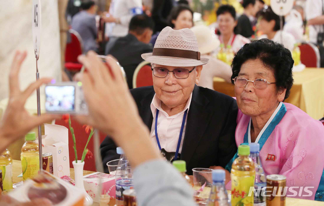 【금강산=뉴시스】김진아 기자 = 이산가족 상봉행사 1회차 둘째날인 21일 북한 금강산호텔에서 열린 단체상봉에서 남측 유관식(89) 할아버지가 딸 유연옥(67)과 사진을 찍고 있다. 2018.08.21. bluesoda@newsis.com