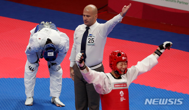 【자카르타(인도네시아)=뉴시스】추상철 기자 = 21일(현지시각) 오후 인도네시아 자카르타 컨벤션센터에서 열린 2018 자카르타-팔렘방 아시안게임 태권도 여자 57kg급 결승 경기. 대한민국 이아름이 중국 루오종시에게 패한 후 아쉬워하고 있다. 2018.08.21. scchoo@newsis.com