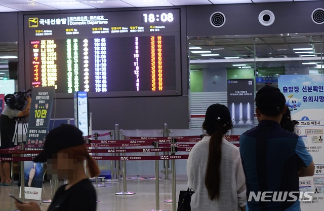 【제주=뉴시스】배상철 기자 = 22일 오후 6시를 기점으로 제주공항에서 출발하는 모든 항공편이 결항됐다. 관광객들이 제주공항의 국내선 출발 현황판을 바라보고 있다. 2018.08.22.&nbsp; bsc@newsis.com 