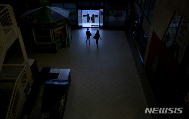 【마라카이보=AP/뉴시스】산유국임에도 불구하고 극심한 경제위기를 겪고 있는 베네수엘라 마라카이보에서 19일 시민들이 정전으로 어두워진 쇼핑몰 밖으로 나가고 있다. 2018.08.23