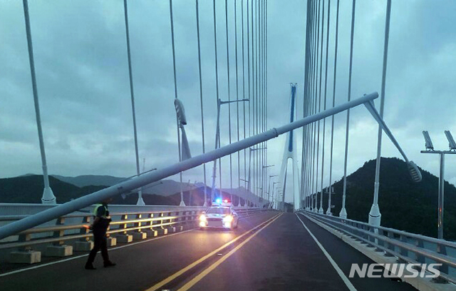 【여수=뉴시스】변재훈 기자 = 19호 태풍 '솔릭'의 북상하고 있는 가운데 23일 오전 5시께 전남 여수시 남면 화태대교 위 가로등이 강풍에 쓰러졌다. 소방당국 등은 크레인을 동원해 1시간 만에 도로에 넘어진 가로등을 철거했다. 2018.08.23. (사진 = 전남 여수소방서 제공) photo@newsis.com