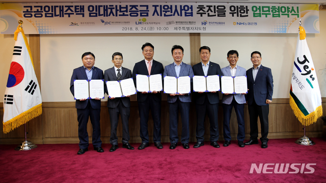 【제주=뉴시스】강정만 기자 = 24일 제주도청 백록홀에서 제주특별자치도와 JDC·LH 제주지역본부·제주개발공사·한국주택금융공사 제주지사·농협은행 제주영업본부 관계자들이 '공공임대주택 임대차보증금 지원사업 추진을 위한 업무협약'을 체결한 후 협약서를 들어보이고 있다. 2018.08.24 (사진= 제주도청 제공) photo@newsis.com&nbsp; 
