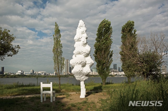 【서울=뉴시스】 박현주 미술전문기자 = 신치현의 한강나무-P6 .실제 미루나무를 본 떠 픽셀(pixel)화 한 작품으로, 멀리서 나무의 형상으로 인식되지만 가까이 다가갈수록 파편화된 디지털 모드의 이미지로 보여지는 착시를 통해 인간이 지닌 단편적 시각의 한계를 보여준다. 나무 옆에 놓이는 의자는 한강의 파노라마가 펼쳐지는 제방에 설치되어 가상과 현실의 경계가 모호하게 느껴지는 이색적 공간 속 시민들이 쉬어갈 수 있는 쉼터가 된다.