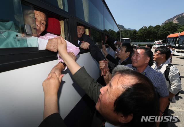 【금강산=뉴시스】뉴스통신취재단 = 제21차 이산가족 상봉행사 2회차 마지막날인 26일 오후 금강산호텔에서 열린 작별상봉 및 공동중식을 마친 이산가족이 버스 창문 너머로 손을 잡고 작별인사를 나누고 있다. 2018.08.26.          photo@newsis.com