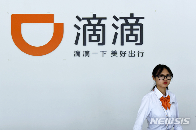 【항저우=AP/뉴시스】중국 교통운수부가 5일 전국 차량 호출 플랫폼의 카풀 서비스에 대한 전면 조사에 착수한다. 최근 '중국판 우버'로 불리는 차량공유업체 디디추싱 운전자들이 여성 승객을 살해하면서 시민 불안이 높아진데 따른 것이다. 지난 2016년 6월13일 저장성 항저우의 디디추싱 서비스센터에서 한 직원이 걸어가는 모습. 208.09.04 