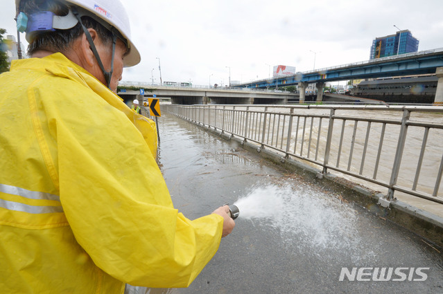 【대구=뉴시스】우종록 기자 = 많은 비가 내리며 대구에 호우경보가 내려진 27일 오전 대구 북구 대현동 칠성교 아래 신천동로에서 시설공단 관계자가 빗물에 떠내려온 나뭇가지를 제거하고 있다. 2018.08.27.&nbsp; wjr@newsis.com 