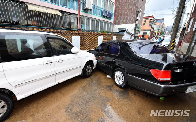 【광주=뉴시스】류형근 기자 =&nbsp; 폭우 특보가 내려진 27일 오전 광주 남구 주월동 인근 골목길에 주차된 차량과 주택 등이 침수 피해를 입은 가운데 차량들이 뒤엉켜 있다. 2018.08.27. hgryu77@newsis.com