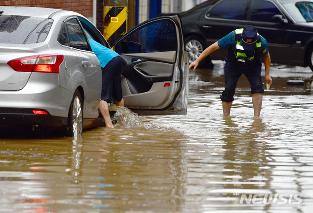 【광주=뉴시스】류형근 기자 =&nbsp; 폭우 특보가 내려진 27일 오전 광주 남구 주월동 인근 골목길에 주차된 차량과 주택 등이 침수 피해를 입은 가운데 경찰과 주민이 막혀 있는 배수구를 찾아 물을 빼고 있다. 2018.08.27. hgryu77@newsis.com