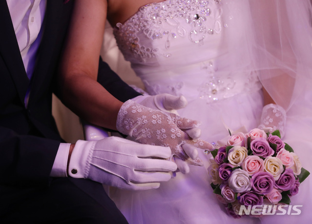 【가평=뉴시스】조수정 기자 = 27일 오전 경기 가평군 청심평화월드센터에서 열린 세계평화통일가정연합 창시자 문선명 총재 천주성화 6주년 기념 성화축제 및 효정 국제 합동축복결혼식에서 신랑신부들이 손을 꼭 잡고 있다. 이날 합동결혼식에서는 4000여쌍의 신랑신부들이 결혼식을 올렸다. 2018.08.27. chocrystal@newsis.com