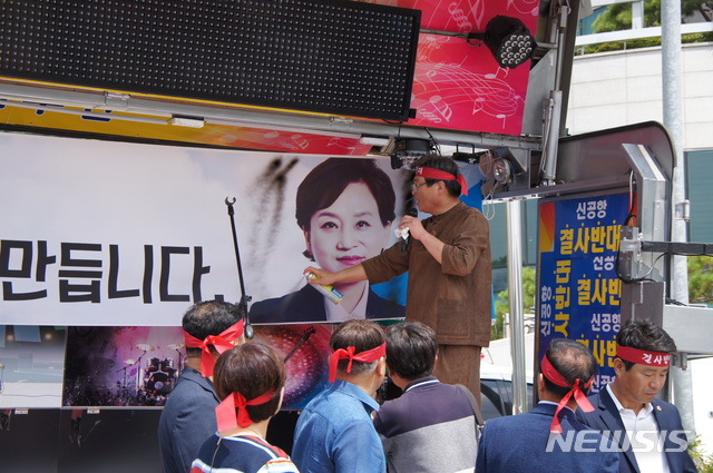 【김해=뉴시스】김상우 기자 =김해신공항 대책 민관협의회는 28일 경남 김해시청 앞 주차장에서 소음 안전대책 등에 문제점이 있다며 정부정책 재검토를 촉구하는 피해대책 보고회를 열었다. 이 자리에서 류경화 김해신공항반대대책위원장은 주관부처인 국토부가 미온적인 대처로 일관하고 있다며 현수막에 있는 김현미 장관 얼굴 부근에 스프레이를 뿌리며 항의했다. 2018.08.28&nbsp;&nbsp; woo@newsis.com