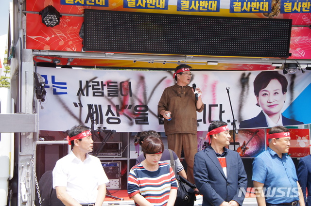 【김해=뉴시스】김상우 기자 = 김해신공항 대책 민관협의회는 28일 김해시청 앞 주차장에서 소음 안전대책 등에 문제점이 있다며 정부정책 재검토를 촉구하는 피해대책 보고회를 열었다. 이 자리에서 류경화 김해신공항반대대책위원장은 주관부처인 국토부가 미온적인 대처로 일관하고 있다며 현수막에 있는 김현미 장관 얼굴 부근에 스프레이를 뿌리며 항의했다. 2018.08.28&nbsp;&nbsp; woo@newsis.com