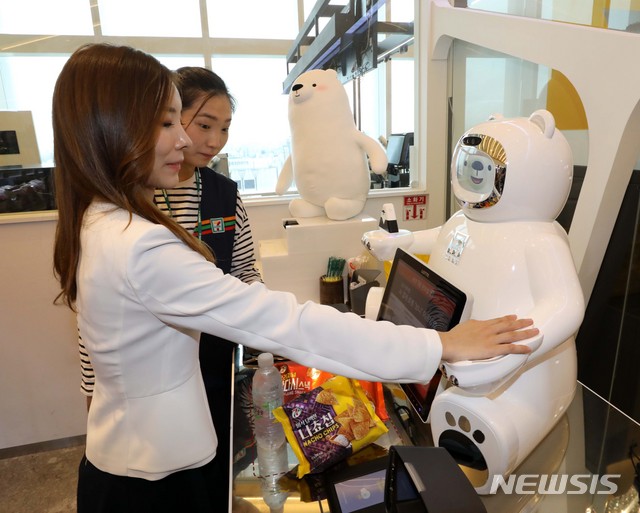【서울=뉴시스】 고범준 기자 = 28일 오전 서울 송파구 롯데월드타워 세븐일레븐 시그니처점에서 모델과 직원이 인공지능 결제 로봇 '브니'를 통해 물건 결제를 하고 있다. 2018.08.28.&nbsp; bjko@newsis.com