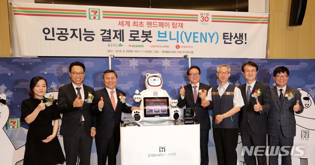 【서울=뉴시스】 고범준 기자 = 28일 오전 서울 송파구 롯데월드타워 오디토리움에서 열린 인공지능 결제 로봇 '브니' 기자 간담회에서 정승인(오른쪽 네번째) 세븐일레븐 대표, 마용득(왼쪽 세번째) 롯데정보통신 대표를 비롯한 참석 내빈들이 기념촬영을 하고 있다. 2018.08.28.&nbsp; bjko@newsis.com