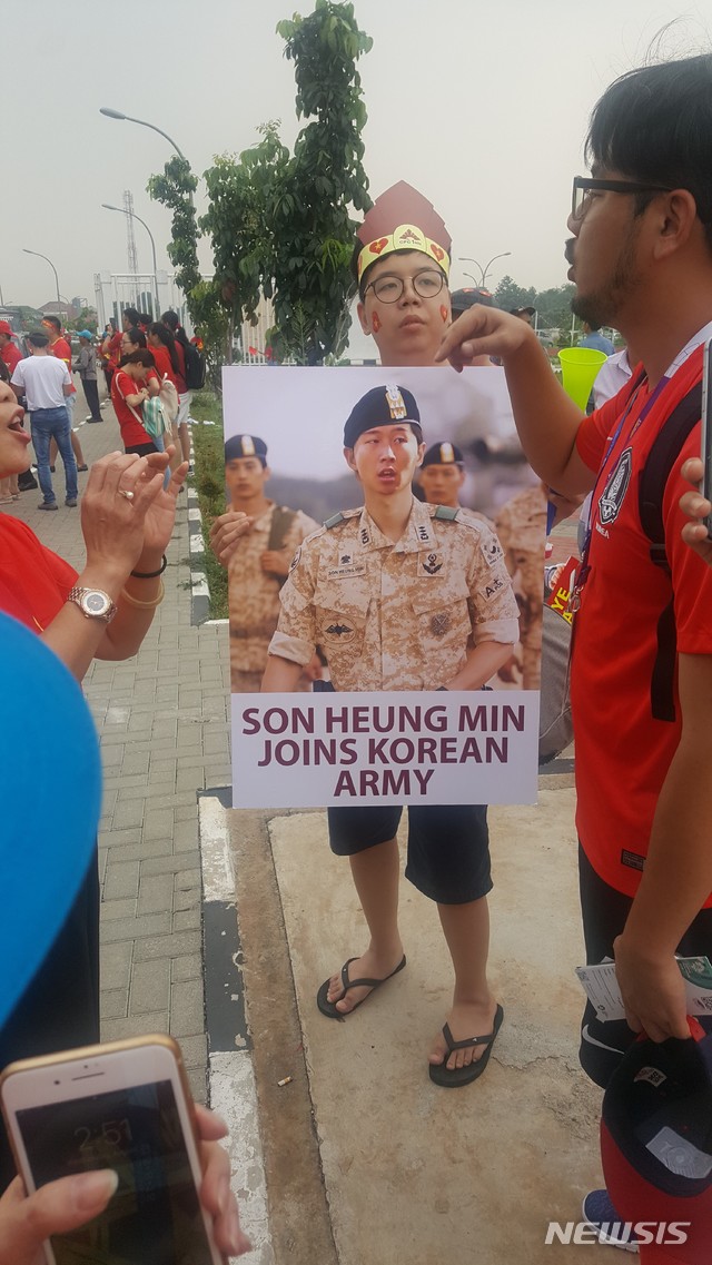 【치비농(인도네시아)=뉴시스】 박지혁 기자 = 29일 인도네시아 보고르 치비농의 파칸사리 스타디움에서 열리는 한국-베트남의 2018 자카르타·팔렘방 아시안게임 축구 준결승전에 앞서 한 베트남팬이 손흥민의 입대를 기원하며 군복을 입은 손흥민의 합성사진을 들고 있다. fgl75@newsis.com
