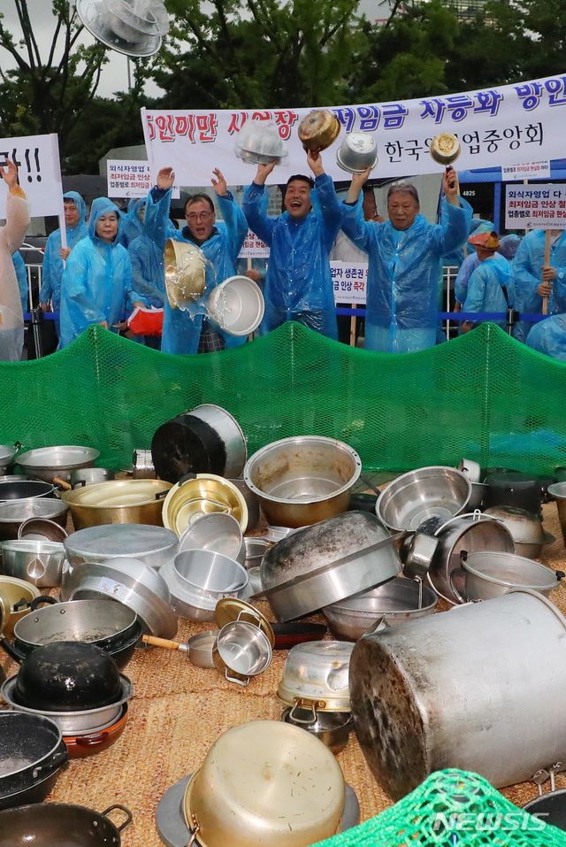 【서울=뉴시스】배훈식 기자 = 29일 오후 서울 종로구 광화문 광장에서 열린 8.29 소상공인 총궐기 최저임금 제도개선 촉구 국민대회에 참석한 소상공인들이 최저임금 제도개선을 촉구하며 주방기구들을 던지고 있다. 2018.08.29.&nbsp; dahora83@newsis.com