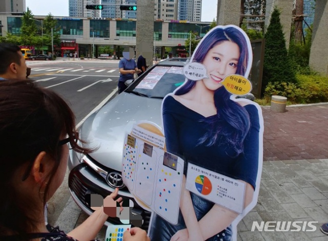 【인천=뉴시스】 이정용 기자 = 30일 오전 인천 송도국제도시 내 H아파트 인도에 방치된 50대 여성 입주민 차량 앞에 설현 입간판이 놓여져있다. 입간판에는 '언니 차 빼 주세요!!', '아이들이 위험해요~'라는 말풍선이 붙어져 있었고 주민 의견을 묻는 설문조사도 진행 중이다. 차주인 50대 여성은 자신의 차량에 아파트단지 불법주차 스티커가 부착된 것에 화가 나 27일 오후 5시 아파트 정문 지하주차장 진입로를 막고 사라졌다. 2018.08.30. stay@newsis.com