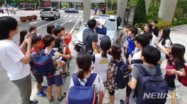 【인천=뉴시스】 이정용 기자 = 30일 오전 인천 송도국제도시 내 H아파트 인도에 방치된 50대 여성 입주민 차량 앞에 설현 입간판이 놓여져있다. 입간판에는 '언니 차 빼 주세요!!', '아이들이 위험해요~'라는 말풍선이 붙어져 있었고 주민 의견을 묻는 설문조사도 진행 중이다. 인근 초등학생들이 몰려와 입간판에 투표를 하고 있다. 차주인 50대 여성은 자신의 차량에 아파트단지 불법주차 스티커가 부착된 것에 화가 나 27일 오후 5시 아파트 정문 지하주차장 진입로를 막고 사라졌다. 2018.08.30. stay@newsis.com