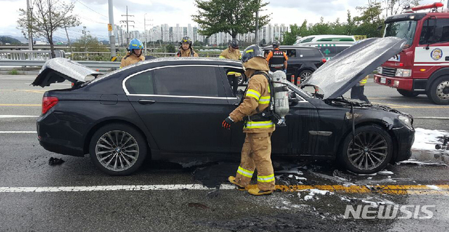 【대전=뉴시스】함형서 기자 = 30일 오후 대전 유성구의 한 도로를 달리던 BMW 750i 승용차에서 불이나 출동한 119소방대원들이 화재를 진화한 뒤 차량을 살펴보고 있다. 이 화재로 다행이 인명피해는 없다.화재가 난  BMW 750i 승용차는 휘발유 차량으로 리콜 대상이 아니다.경찰과 소방당국은 정확한 화재원인을 조사하고 있다. 2018.08.30.(사진= 대전지방경찰청 제공)photo@newsis.com