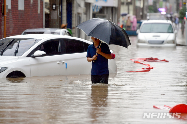 【광주=뉴시스】류형근 기자 = 호우특보가 내려진 31일 오전 광주 남구 주월동 주택가 골목길이 폭우에 침수된 가운데 한 주민이 우산을 쓴채 빠져나오고 있다. 이곳은 지난 27일에도 폭우에 침수돼 많은 피해를 입었다. 2018.08.31.&nbsp; hgryu77@newsis.com