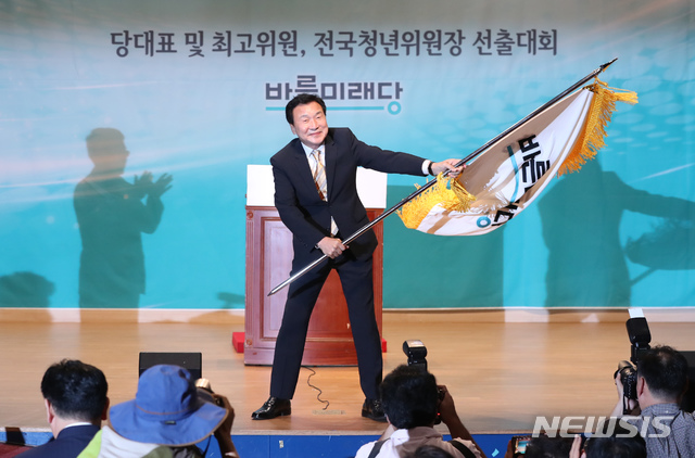 【서울=뉴시스】고승민 기자 = 2일 오후 서울 여의도 국회 의원회관에서 열린 바른미래당 당대표 및 최고위원, 전국청년위원장 선출대회에서 당대표로 선출된 손학규 후보가 김동철 비대위원장으로부터 당기를 전달받은 뒤 흔들고 있다. 2018.09.02.kkssmm99@newsis.com