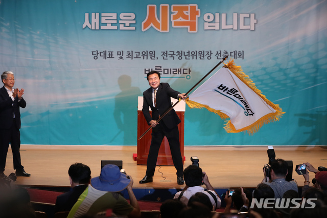 【서울=뉴시스】고승민 기자 = 2일 오후 서울 여의도 국회 의원회관에서 열린 바른미래당 당대표 및 최고위원, 전국청년위원장 선출대회에서 당대표로 선출된 손학규 후보가 김동철 비대위원장으로부터 당기를 전달받은 뒤 흔들고 있다. 2018.09.02. kkssmm99@newsis.com