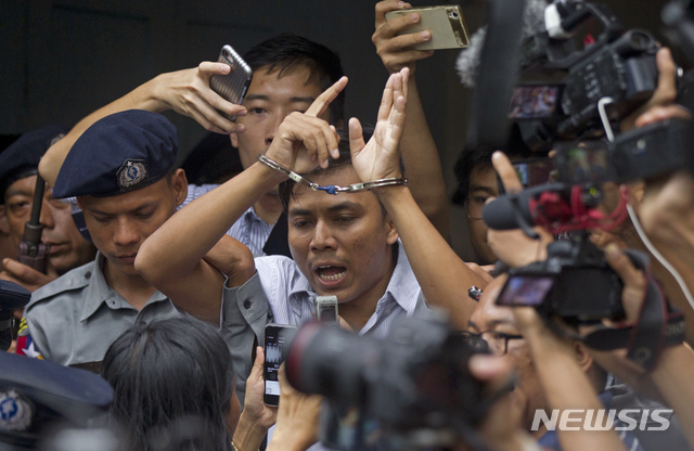 Reuters journalist Kyaw Soe Oo, center, talks to journalists during he is escorted by police as he leaves the court Monday, Sept. 3, 2018, in Yangon, Myanmar. A Myanmar court sentenced two Reuters journalists, Wa Lone and Kyaw Soe Oo, to seven years in prison Monday for illegal possession of official documents, a ruling that comes as international criticism mounts over the military's alleged human rights abuses against Rohingya Muslims. (AP Photo/Thein Zaw)