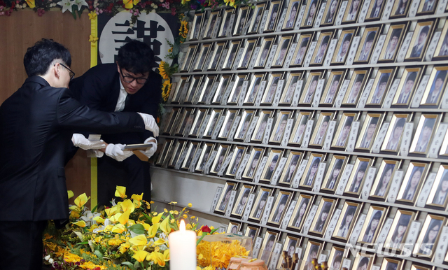 【진도=뉴시스】변재훈 기자 = 3일 오후 전남 진도군 임회면 팽목항에 설치됐던 세월호 참사 희생자 분향소에서 진도군청 직원들이 참사 희생자의 사진을 정리하고 있다. 2018.09.03.&nbsp; wisdom21@newsis.com