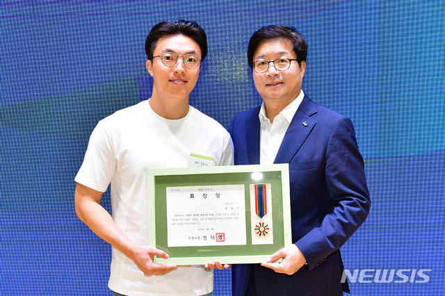 【수원=뉴시스】김경호 기자= 4일 경기 수원시청 대강당에서 선행시민 표창상을 받은 류광현(34)씨와 염태영 수원시장이 포즈를 취하고 있다. 2018.09.04 (사진 = 수원시 제공) photo@newsis.com