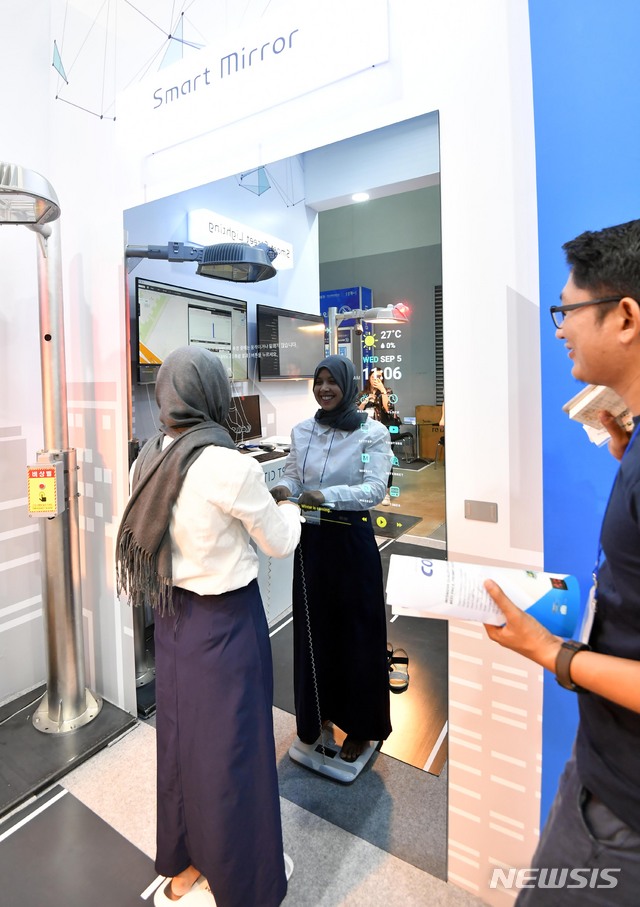 【부산=뉴시스】 하경민 기자 = 5일 부산 벡스코 제2전시장에서 열린 '2018 K-ICT WEEK in BUSAN'을 찾은 외국인 여성이 체성분 검사 기능을 갖추고 있는 스마트 미러를 체험하고 있다. 7일까지 열리는 이번 행사는 '제14회 IT 엑스포 부산'와 '제6회 클라우드 엑스포 코리아', '제5회 ITU유스포럼'이 동시에 열리며, 국내 156개 IT기업이 참가해 ICT기반 융합SW와 모바일, 통신, 방송, 클라우드 분야별 제품과 서비스를 선보인다. 2018.09.05. yulnetphoto@newsis.com