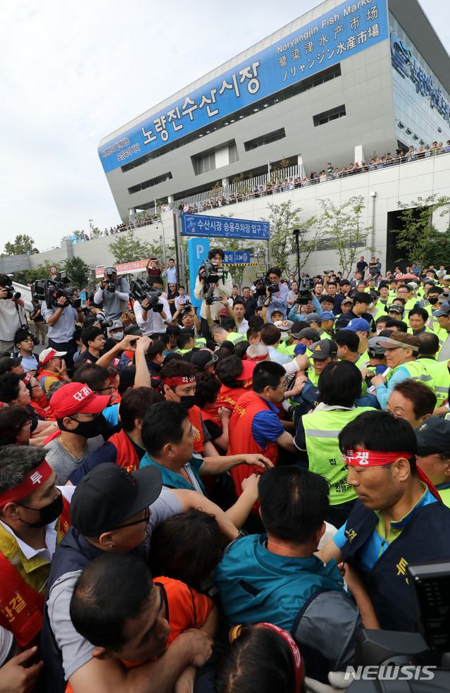 【서울=뉴시스】박주성 기자 = 수협의 구 노량진수산시장 명도 강제집행이 실시된 6일 오전 서울 동작구 노량진수산시장에서 구시장 상인들과 집행 관계자들이 몸싸움을 하고 있다. 2018.09.06. park7691@newsis.com