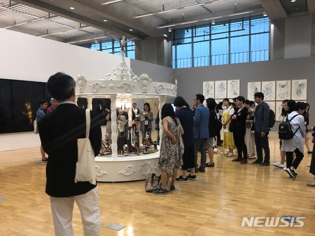 【서울=뉴시스】 박현주 미술전문기자 = 광주비엔날레 7개 섹션별 전시중 김만석-김성우-백종옥 큐레이터가 기획한 ‘생존의 기술: 집결하기, 지속하기, 변화하기’(The Art of Survival: Assembly, Sustainability, Shift)는 전시된 민성홍 작가의 궁전같은 새장을 관람객들이 보고 있다. 국립아시아문화전당 문화창조원 복합 5관에서 선보인 이 작품은 '물에는 자성이 없다'는 제목으로 떠나는 사람들이 내다버린 일상의 잡동사니들을 모아 하나의 작품으로 탄생시켰다. 이쑤시개로 새장의외부를 장식하여 새장의 기능을 가진 사물에 대한 고정관념을 깨트린다.