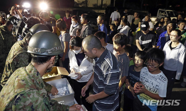 【아쓰마(홋카이도)=교도·AP/뉴시스】일본 자위대원들이 6일 저녁 홋카이도의 아쓰마 정에 있는 한 지진대피소에서 시민들에게 음식물을 배포하고 있다. 홋카이도에서는 이날 새벽 규모 6.7의 강진이 발생했다. 2018.09.07.&nbsp; 