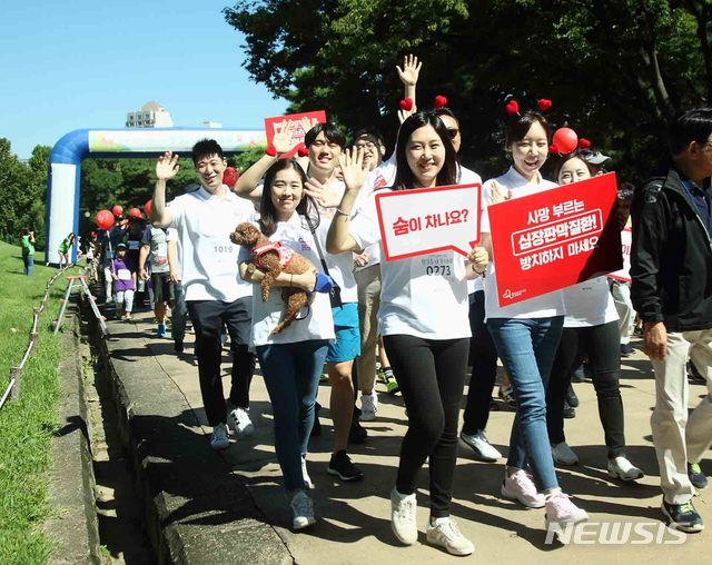 【서울=뉴시스】8일 서울 송파구 올림픽공원에서 한국심장재단이 주최한 '2018 심장병 예방을 위한 한걸음 더 걷기대회'에서 에드워즈라이프사이언시스코리아 임직원들이 심장판막질환 인식 향상을 위한 캠페인을 펼치고 있다. 2018.09.08. (사진=에드워즈라이프사이언시스코리아 제공) photo@newsis.com