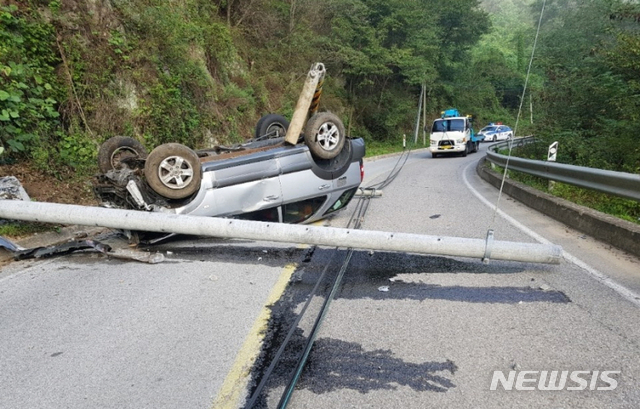 【영동=뉴시스】송휘헌 기자 = 9일 오전 7시께 충북 영동군 용산면 한 도로에서 전신주를 들이받은 승용차가 전복돼 있다. 2018.09.09. (사진=독자 제공)photo@newsis.com