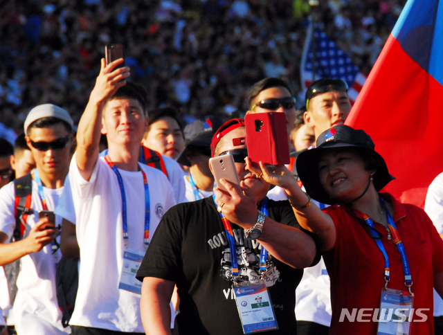 【충주=뉴시스】이병찬 기자 = 9일 충북 충주종합운동장에서 열린 2018충주세계소방관경기대회 개막식에서 입장하던 외국 선수들이 휴대전화로 사진을 찍고 있다.2018.09.09.&nbsp;&nbsp; bclee@newsis.com 