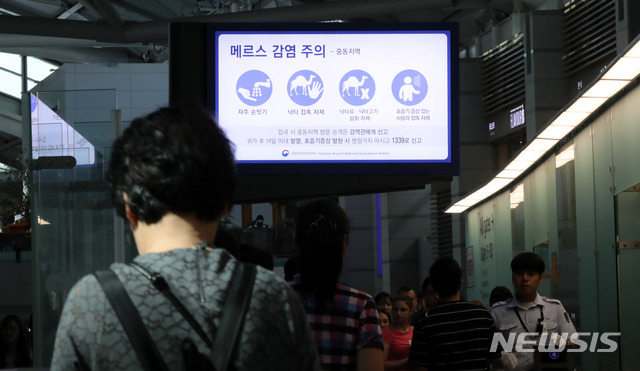 【인천공항=뉴시스】홍찬선 기자 = 중동호흡기증후군(MERS·메르스) 확진 환자가 발생한 가운데 10일 오전 인천공항 제1여객터미널 출국장에서 승객들이 메르스 감염 주의 안내문을 바라보고 있다. 한편 인천공항공사와 검역소는 인천공항의 위기 경보를 관심에서 '주의'로 한단계로 격상했다. 2018.09.10.&nbsp; mania@newsis.com