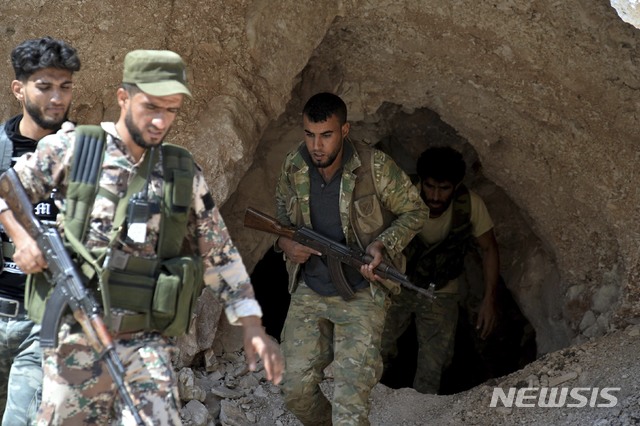 【지스르 알 슈후르=AP/뉴시스】 9일(현지시간) 시리아 이들립주 북부에 위치한 지스르 알 슈후르의 한 동굴에서 반정부군사조직인 자유시리아군이 나오고 있다. 2018.9.11