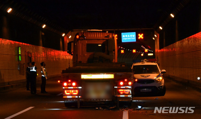 【부산=뉴시스】 하경민 기자 = 11일 부산과 경남 거제시를 잇는 거가대교 위에서 술에 취한 상태로 트레일러를 몰던 A(57)씨가 도로를 가로막고 차량을 들이받는 등 난동을 부리며 경찰과 대치하다 약 5시간 만에 붙잡혔다고 부산경찰청은 밝혔다.대치 과정에서 경찰은 트레일러 앞바퀴에 공포탄 1발과 실탄 3발을 발사했고, 오전 4시 58분께 A씨가 차량을 세우고 바다로 투신하겠다며 차량 조수석 문을 열려고 하자 경찰특공대가 운전석과 앞 유리 등을 파손하고 내부로 진입해 A씨 검거했다. 2018.09.11. (사진=부산경찰청 제공)yulnetphoto@newsis.com