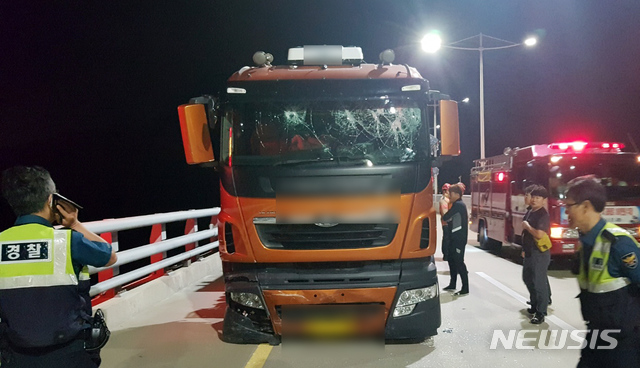 【부산=뉴시스】 하경민 기자 = 11일 부산과 경남 거제시를 잇는 거가대교 위에서 술에 취한 상태로 트레일러를 몰던 A(57)씨가 도로를 가로막고 차량을 들이받는 등 난동을 부리며 경찰과 대치하다 약 5시간 만에 붙잡혔다고 부산경찰청은 밝혔다. 대치 과정에서 경찰은 트레일러 앞바퀴에 공포탄 1발과 실탄 3발을 발사했고, 오전 4시 58분께 A씨가 차량을 세우고 바다로 투신하겠다며 차량 조수석 문을 열려고 하자 경찰특공대가 운전석과 앞 유리 등을 파손하고 내부로 진입해 A씨 검거했다. 2018.09.11. (사진=부산경찰청 제공)yulnetphoto@newsis.com