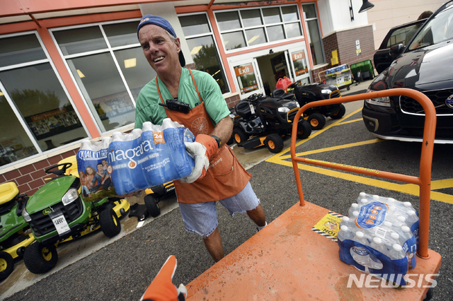 【윌밍턴(미 노스캐롤라이나주)=AP/뉴시스】허리케인 플로렌스가 접근하고 있는 미 노스 캐롤라이나주 윌밍턴에서 10일(현지시간) 한 남성이 허리케인에 대비해 산 물품들을 차에 싣기 위해 옮기고 있다. 미 동부 해안 3개 주에서 강제 대피가 시작된 가운데 수백만명의 주민들이 수십년 래 가장 큰 재앙을 가져올 허리케인 중 하나가 될 플로렌스에 대비하고 있다. 2018.9.11